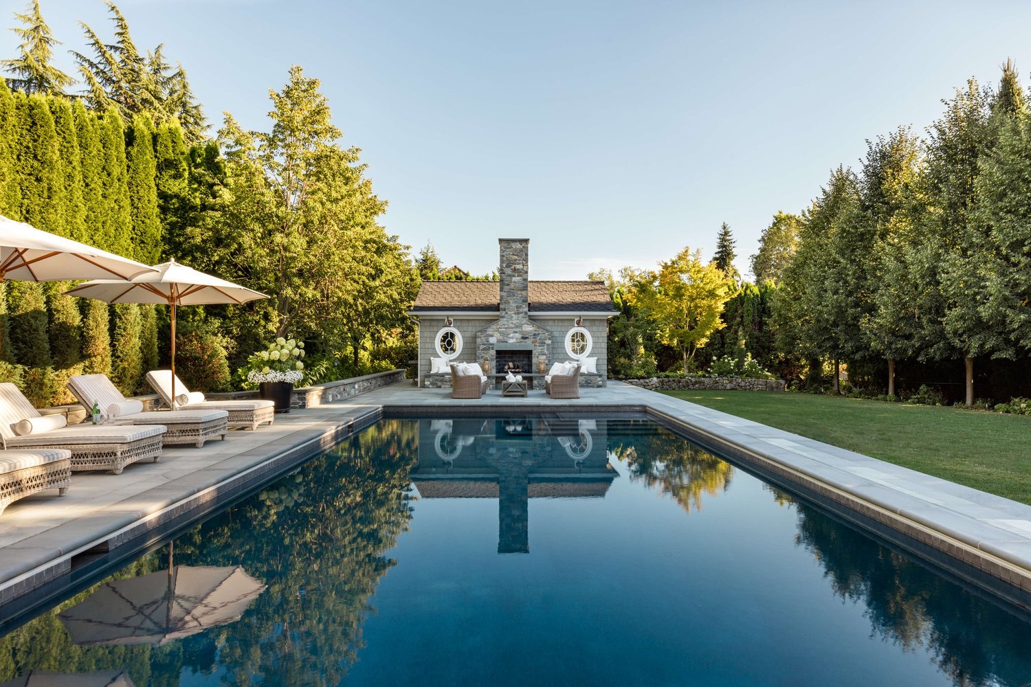 Luxury KrisCo custom pool with stone fireplace and outdoor living space